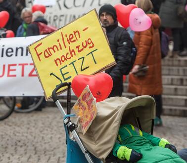 Das Bild zeigt einen Kinderwagen an dem ein Schild befestigt ist: "Familiennachzug jetzt!"