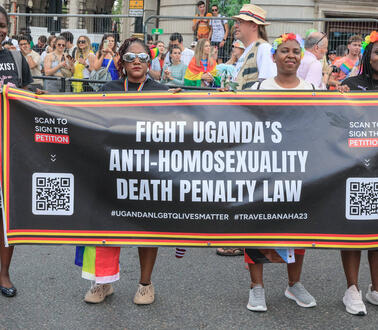 Vier Personen halten während einer Demonstration ein Banner vor sich, auf dem unter anderem steht: "Fight Uganda's Anti-Homosexuality Death Penalty Law".