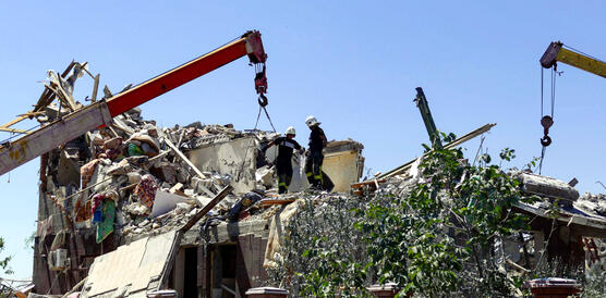 Das Bild zeigt ein Gebäude, das vollständig zerstört ist und Kräne