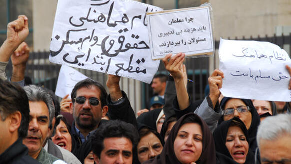 Menschen, die weiße Schilder mit persischer Schrift hochhalten