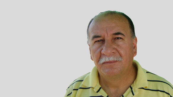 Porträtfoto von Rubén González in gelb-schwarz gestreiftem Hemd