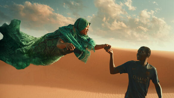 Das Bild zeigt einen jungen Mann, der eine Frau an der Hand hält, sie schwebt über dem Boden