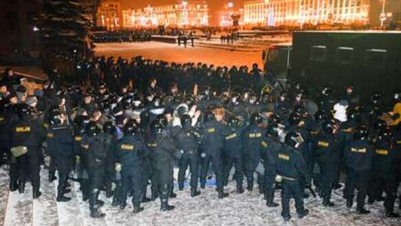 Polizisten stehen Spalier und prügeln auf festgenommene Demonstranten ein, am 19.12.2010 in Minsk