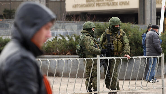 Das Foto zeigt mit Sturmgewhren bewaffnete Soldaten, die hinter einer Gitterabsperrung stehen.